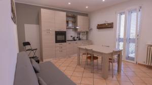 a living room with a table and a kitchen at Spazioso appartamento vicino a tutto in Tortona +9 photos