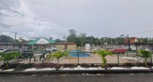 a swimming pool in a parking lot with palm trees at Locação por Temporada e Cop 30 in Ananindeua