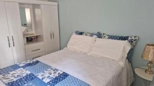 a bedroom with a bed with a blue and white blanket at Locação por Temporada e Cop 30 in Ananindeua +2 photos