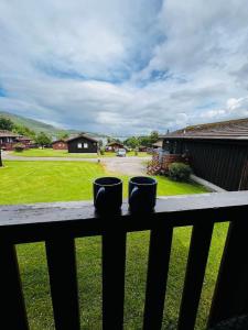 two coffee cups sitting on a rail on a porch at Tigh Na Mara in Dunoon