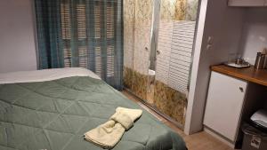 a bedroom with a green bed and a shower at Nafpaktos Happy town studio in port in Nafpaktos