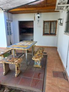 a patio with a picnic table and benches at Los Abuelos in Lobos +1 photo