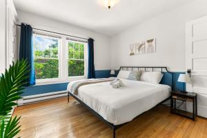 a bedroom with a bed and a window at Spacious 8 bed stay - HOT TUB, Patio, fireplace, 3 full bathrooms private home in Moncton in Moncton