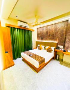a bedroom with a bed and a green curtain at Hotel Franklin delhi Airport in Jāmb