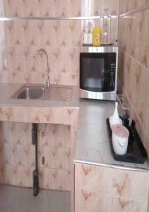 a kitchen with a sink and a microwave at Mame Thierno sene in Niakoul Rap