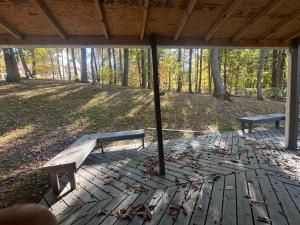 two benches sitting on a deck in the woods at Comfy Getaway in Christiansburg