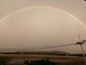a rainbow in the sky over a parking lot at ชมวิว บึงโขงหลง in Bung Khong Long +1 photo