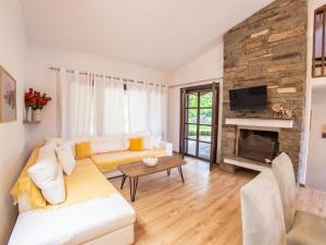 Una sala de estar con un sofá blanco y una chimenea. en Sani Lili 9, en Sani Beach
