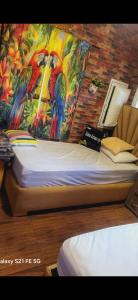 a bed in a room with a painting on the wall at house Ketama vip in Igousdarene