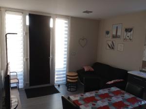 a living room with a black couch and a table at Appartement Béhobie in Urrugne +3 photos