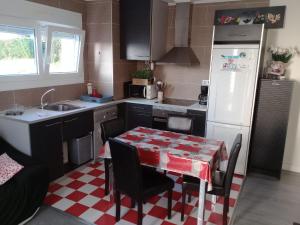 a kitchen with a table and a white refrigerator at Appartement Béhobie in Urrugne