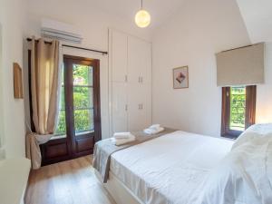 Un dormitorio blanco con una cama y una ventana. en Sani Lili 9, en Sani Beach 32 fotos más