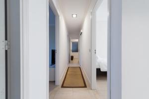 a hallway leading to a bedroom with white walls at Malfu Home in Las Palmas de Gran Canaria