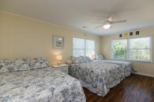 Un dormitorio con dos camas y un ventilador de techo. en Beach Blessing, en Edisto
