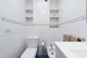 a white bathroom with a toilet and a sink at Malfu Home in Las Palmas de Gran Canaria +49 photos