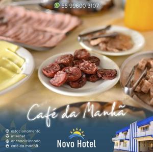 a table with plates of food on top at Novo Hotel in Caçapava do Sul