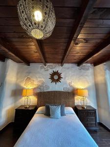 ein Schlafzimmer mit einem Bett, zwei Nachttischen und einem Kronleuchter in der Unterkunft Hotel Boutique Rancho San Jorge in Bernal