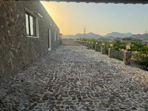a cobblestone street next to a stone building at استرحه ام الحمام in Suḩaybah