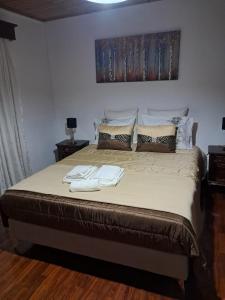 Un dormitorio con una cama grande con dos toallas encima. en Casa Sequeira, en Fajã da Ovelha