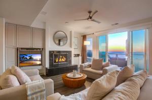 a living room with white furniture and a fireplace at Surf House in Encinitas