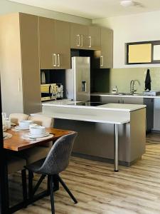 Una cocina y un comedor con mesa y sillas. en Merensky Tower Apartment, en Windhoek