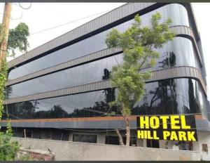 a hotel building with a tree in front of it at HoTEL HILL PARK INDORE AIRPORT in Indore