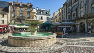 a fountain in the middle of a street with buildings at Bright apartment Disneyland Paris Wi-Fi in Lagny