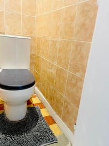 a bathroom with a toilet with a black seat at Bright apartment Disneyland Paris Wi-Fi in Lagny +13 photos