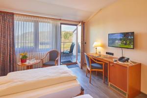 ein Hotelzimmer mit einem Bett und einem Schreibtisch in der Unterkunft Hotel Sonnenblick Bebra in Bebra