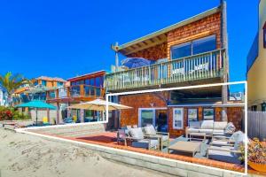 a house on the beach with chairs and a balcony at Jetty View 1 in San Diego