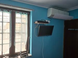 a blue room with a television and a window at Casa do castelo in Penamacor