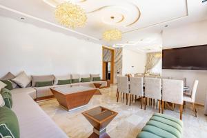 マラケシュにあるVilla Kamélia 5000m Hammam Piscine Chauffée et Sans Vis à Visのソファとテーブルのあるリビングルーム