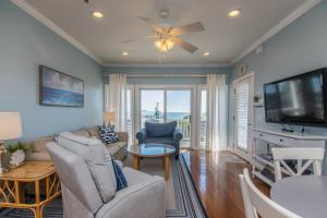 a living room with a couch and a tv at Retreat 5B - Edisto Blessing in Edisto Island