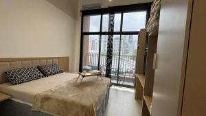 Un dormitorio con una cama y una ventana grande. en Aimbere by You - 20015 - Ótima localização - Allianz Parque - Palmeiras - Perdizes, en São Paulo