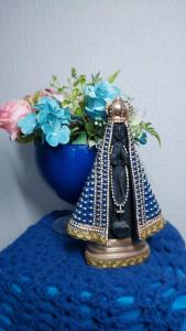 eine Figur des Eiffelturms neben einer Vase mit Blumen in der Unterkunft Cantinho da Vovó in Aparecida