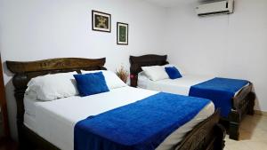 two beds in a room with blue and white at Olas del Mar by GHO Hoteles in Santa Marta +27 photos