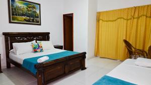 a bedroom with a bed and a yellow curtain at Olas del Mar Hotel by GHO Hoteles in Santa Marta