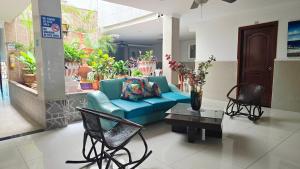 a living room with a blue couch and chairs at Olas del Mar Hotel by GHO Hoteles in Santa Marta