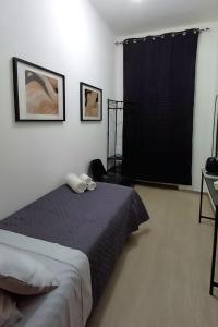 a bedroom with a bed and a black curtain at S'apposentu 'e Santa Ruche in Oniferi