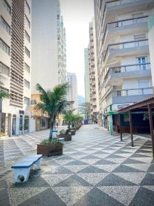 a street in a city with palm trees and buildings at Ap Pitangueiras - 3 suítes - Pé na Areia - Ao lado do Shopping in Guarujá