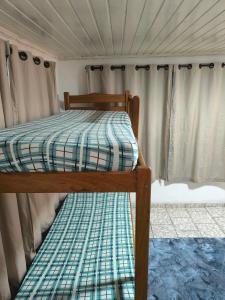 a twin bed in a room with curtains at Apartamento Central in Primavera do Leste