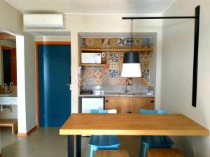 ピレノポリスにあるQSB - Quinta Santa Bárbaraのキッチン(木製テーブル、青い椅子付)