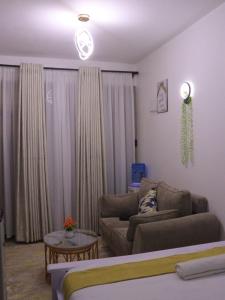 ein Wohnzimmer mit Couch und ein Wohnzimmer mit Vorhängen in der Unterkunft Havenly Homes Stay in Gatunga