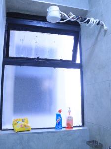 ein Fenster im Badezimmer mit Waschmitteln auf einem Regal in der Unterkunft Havenly Homes Stay in Gatunga
