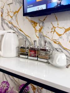 Un estante con tres productos en una pared de mármol. en The Hideout-Studio Apartment in Westlands, en Nairobi 12 fotos más
