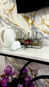 Un estante con dos frascos de perfume y flores encima. en The Hideout-Studio Apartment in Westlands, en Nairobi