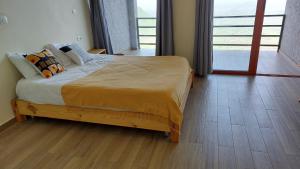 a bed in a bedroom with a wooden floor at Halle Hotel - Lalibela in Lalībela