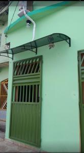 a building with a green garage door and a street light at Meu refúgio 01 in Belém +5 photos