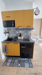 a kitchen with yellow cabinets and a rug at Le Réverbère, appartement de vacances in Lectoure +18 photos