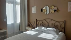 a bedroom with a bed with white sheets and a window at Le Réverbère, appartement de vacances in Lectoure